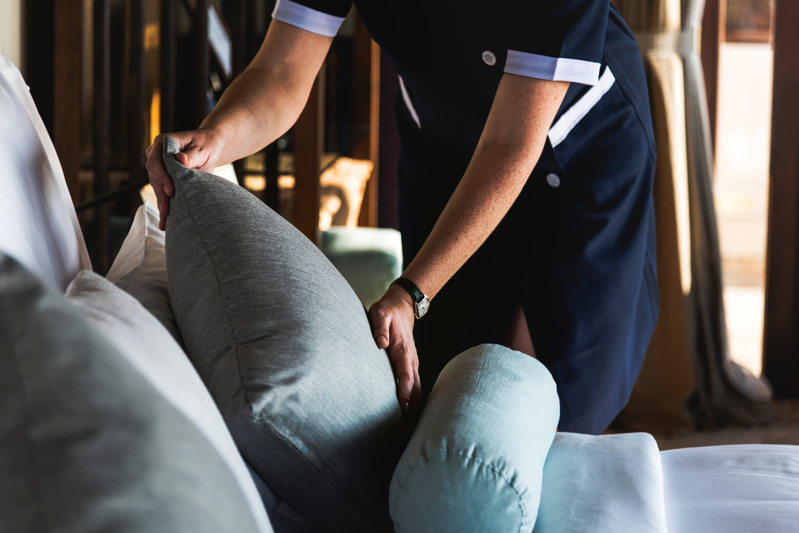 housekeeping arranging pillows on bed