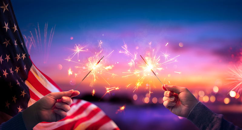 people holding sparklers for the Fourth of July