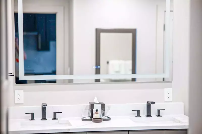 Primary en suite bathroom features a quartz double vanity with LED back-lit mirrors, soaking tub, walk in glass steam shower, and high-end finishes