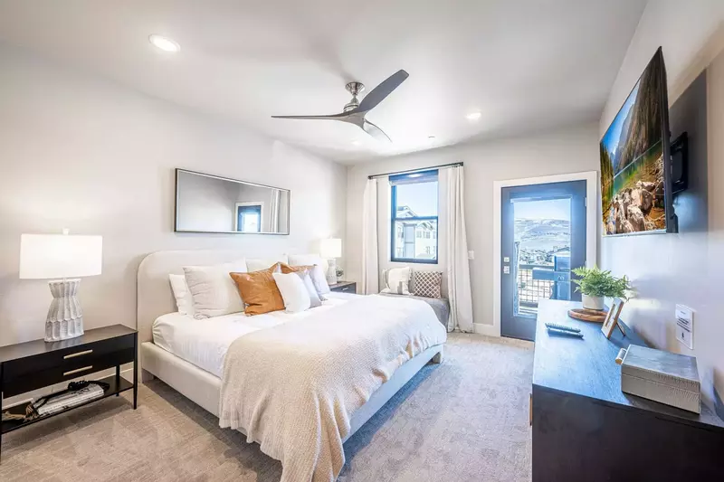 This bedroom features a comfortable king sized bed and two large nightstand as well as a balcony with stunning mountain views