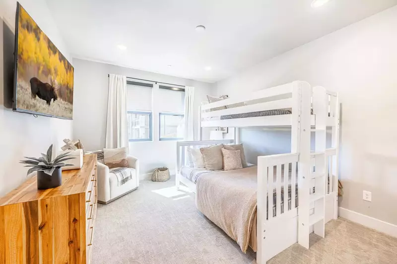 This bunk room has its own tv and a bunk bed with a full sized bed on bottom and twin sized bed on top