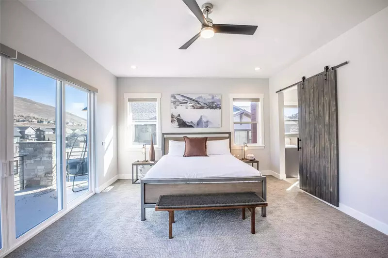 The primary bedroom offers a king sized bed, access to the private balcony, and a luxurious oversized primary en suite bathroom