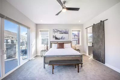 The primary bedroom offers a king sized bed, access to the private balcony, and a luxurious oversized primary en suite bathroom