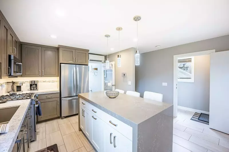 The newly renovated kitchen has stainless steel Bosch appliances including a gas range and french door fridge. The island features a custom waterfall