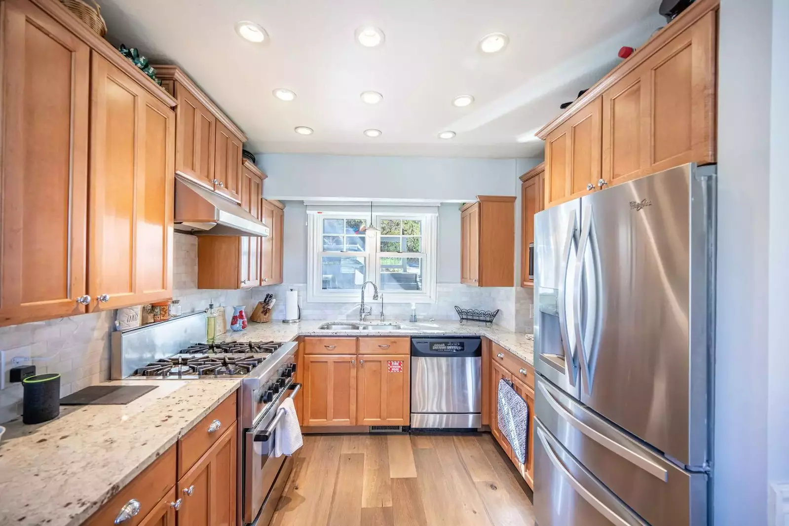 The newly updated kitchen is filled with natural light and beautiful hardwood flooring and granite countertops. The kitchen is fully stocked