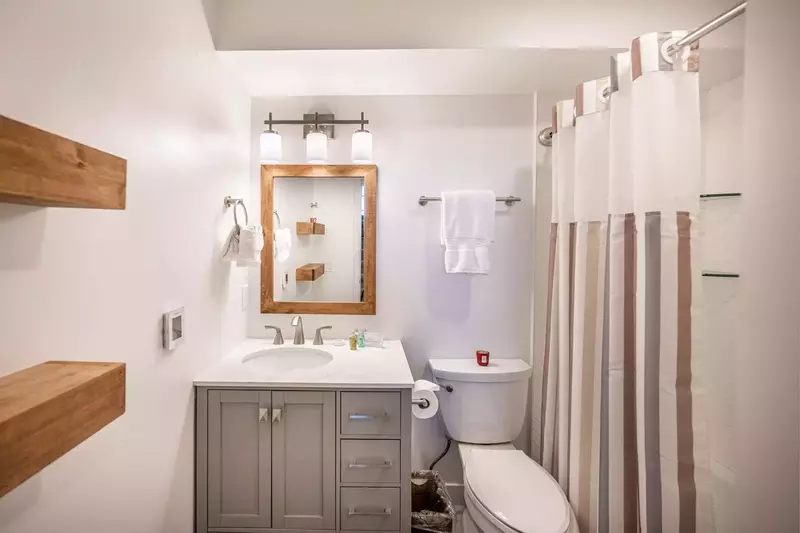 Located just outside the guest room is a bathroom. The middle level bathroom was updated in 2022 and features a new oversized vanity