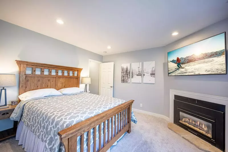 The warm and welcoming lower level guest suite is a perfect retreat with a private fireplace, hot tub access and comfortable queen bed