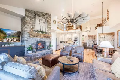 This spacious living room has vaulted ceilings, a large gas fireplace, and open floor plan to the kitchen.