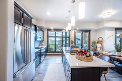 The all new, fully stocked chef's kitchen has stainless steel appliances including a gas range and french door fridge