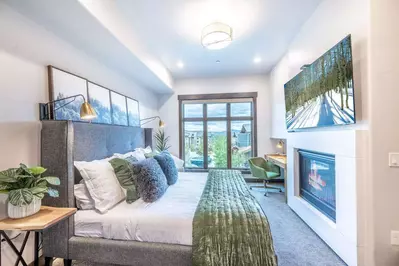 Primary suite features a large gas fireplace and mountain views from the floor to ceiling windows