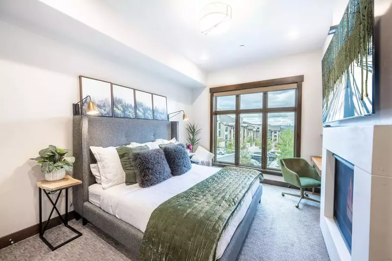 Warm and inviting primary suite that featuring a king sized bed, gas fireplace, private work desk, and large HDTV