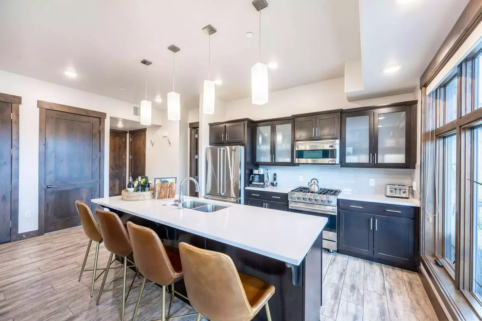 Modern kitchen with upgraded Viking appliances, a gas stove, and an oversized quartz island with a breakfast bar