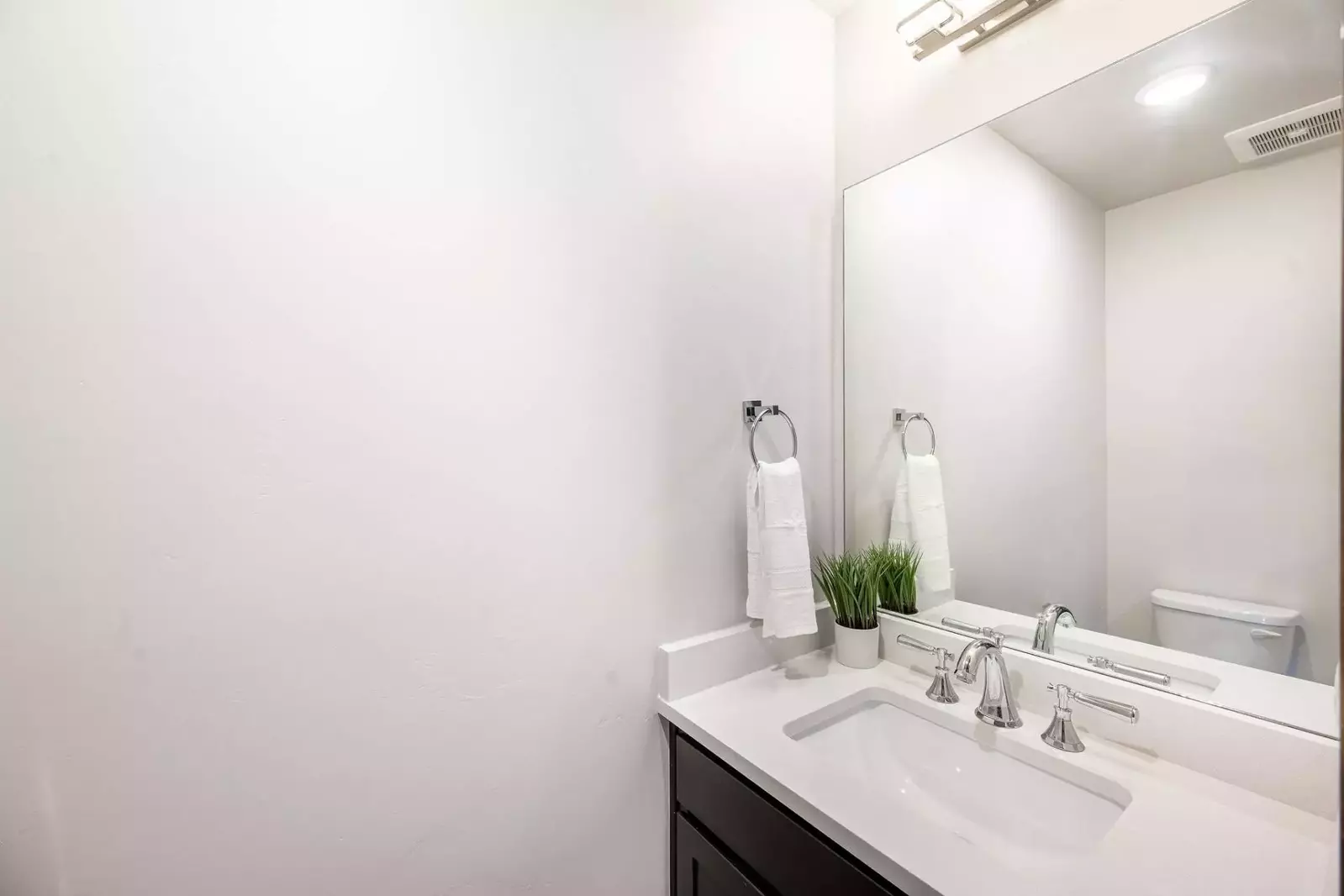 Guests will enjoy the half bathroom just off the entrance of the home