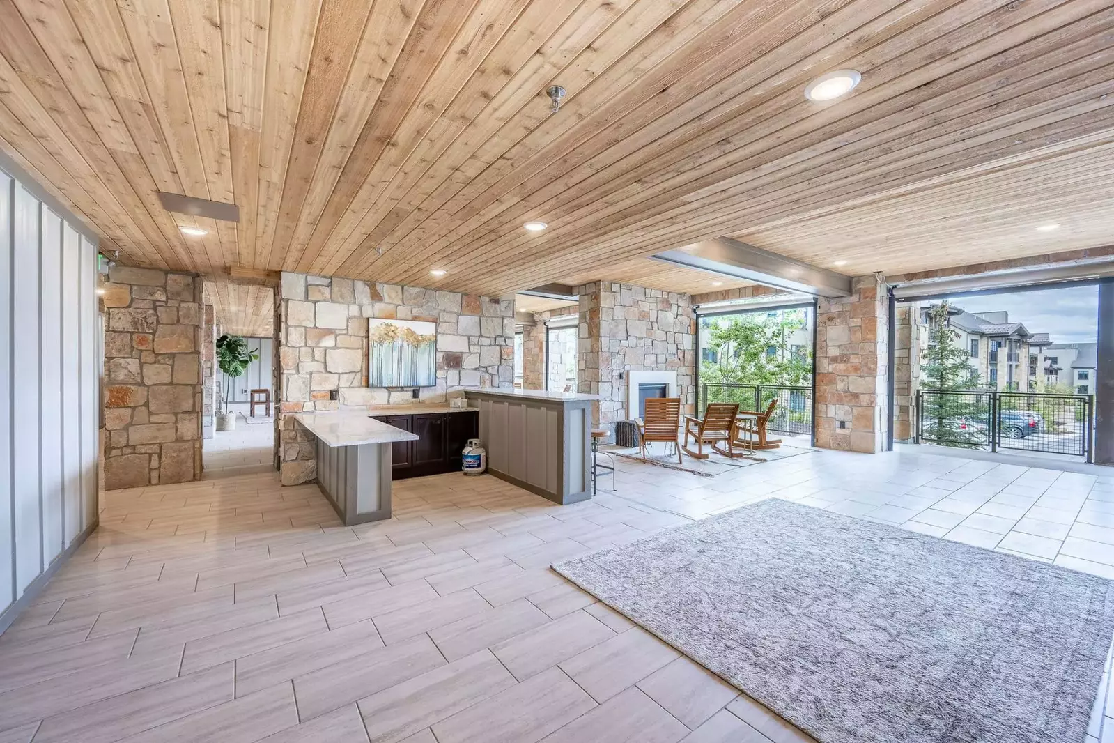 Modern common space with lots of room for entertaining with an outdoor fireplace and outdoor kitchen space