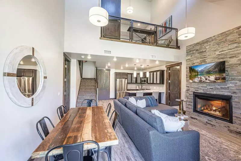 Gorgeous open floor plan with hardwood flooring, vaulted ceilings, and warm natural light. Hardwood dining table with chairs for up to 8 guests, addit
