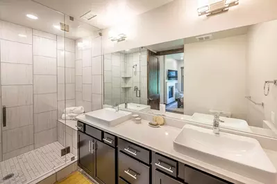 Walk-in glass shower and twin vanities