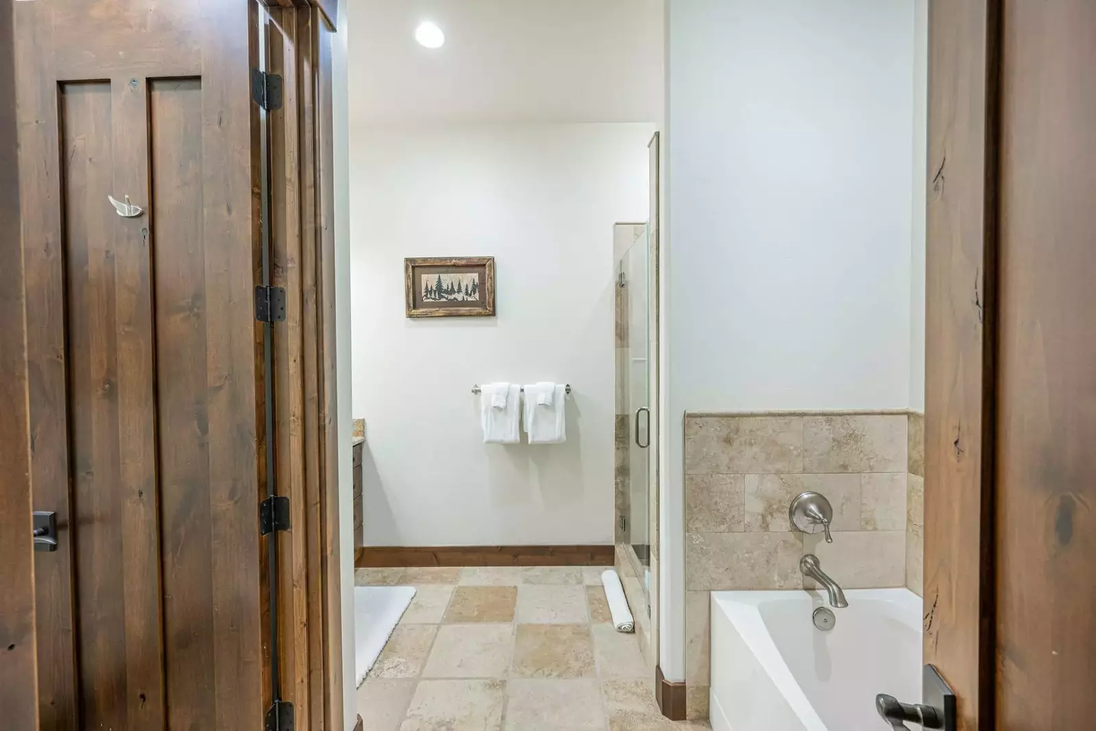 This en suite primary bathroom has a large glass walk in shower and oversized bathtub.