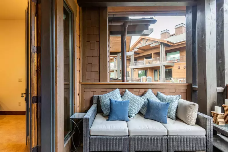 A cozy out door three seater couch on the primary suite's private balcony.