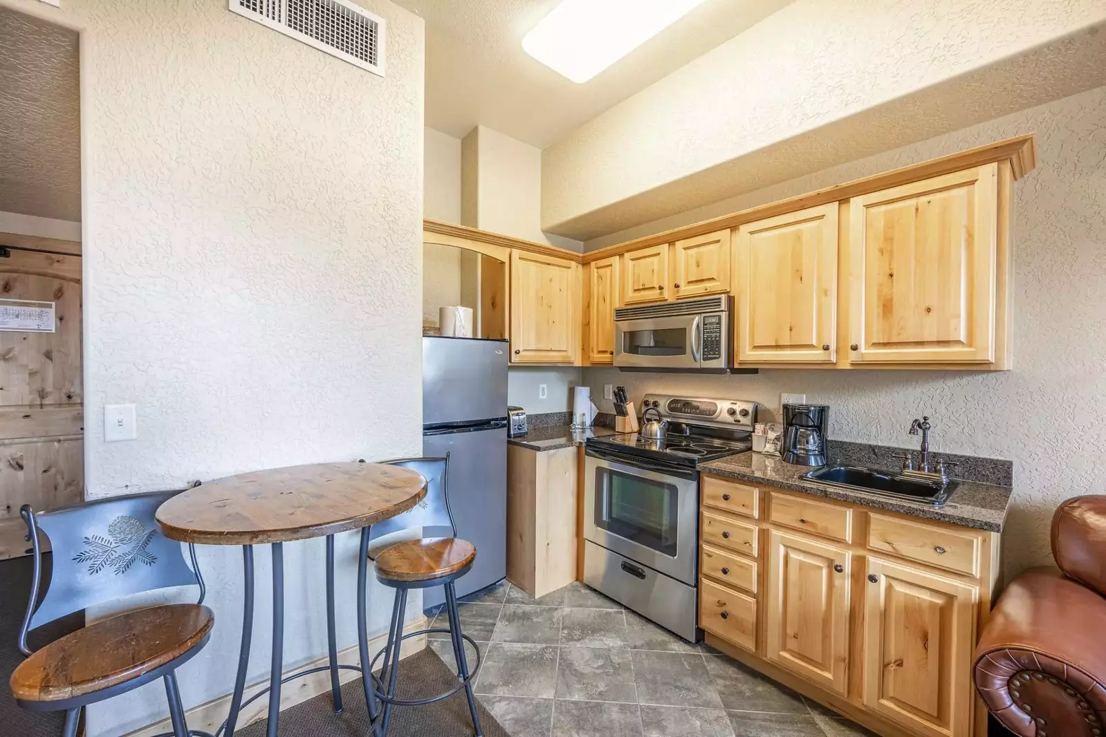 Newly updated, fully equipped kitchen with stainless steel appliances, knotty alder cupboards, and granite countertops and full size stainless applian