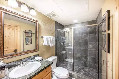 Full and spacious bathroom with walk in shower with a glass door
