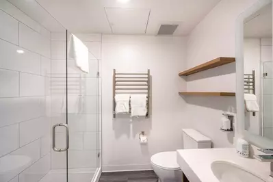 The spacious private bathroom is well appointed with quartz counters, heated towel rack and an oversized walk in shower.