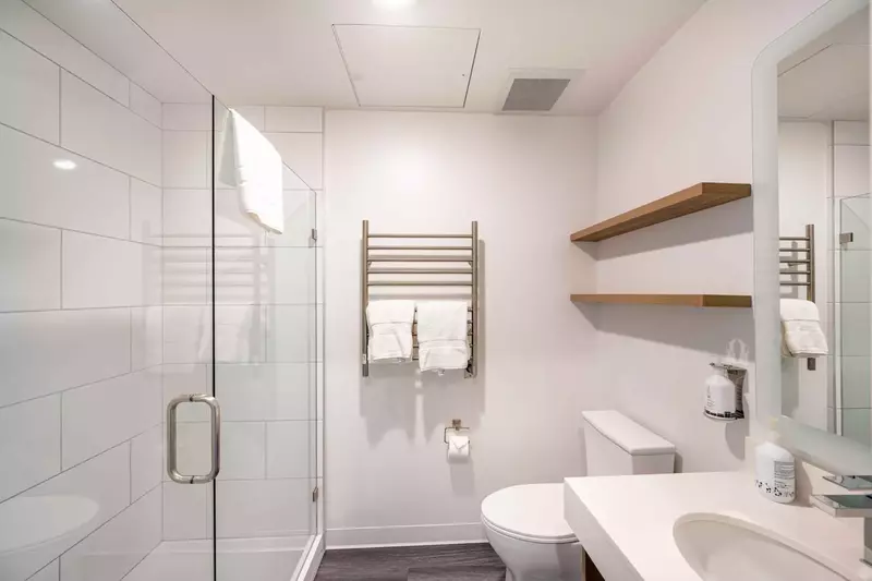 Modern and sleek private bathroom with heated towel rack and a walk in shower