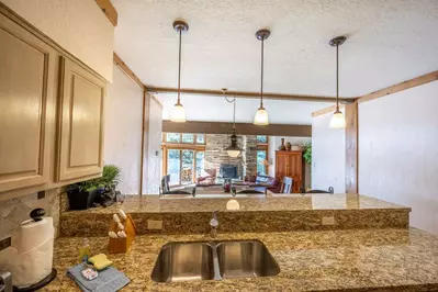 The updated kitchen is fully stocked and has granite counter tops, full size stainless steel appliances, and breakfast bar top seating for three.