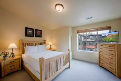 The primary suite features a comfortable queen-sized bed and flatscreen TV