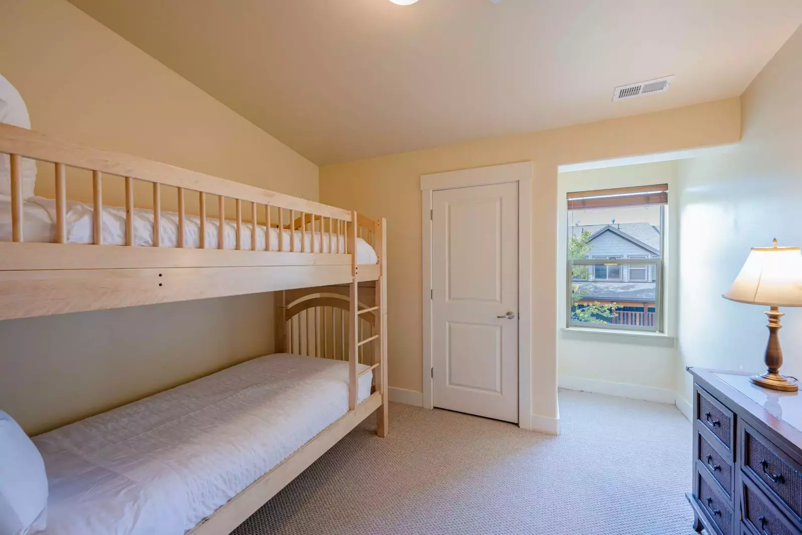 Guest suite is furnished with a wooden twin-sized bunk bed and comfortable sheets