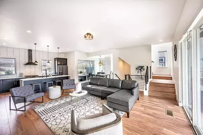 The welcoming open concept floor plan is filled with a refined combination of matte black, chic white and warm woods to create a chic interior