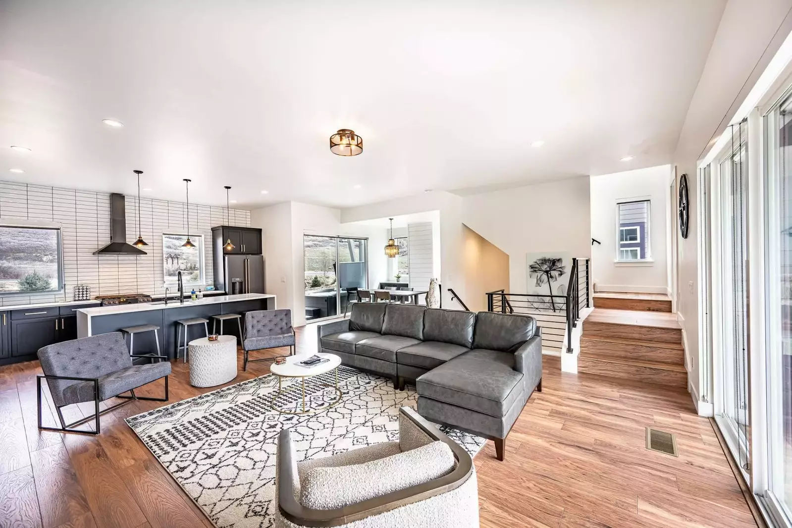 The welcoming open concept floor plan is filled with a refined combination of matte black, chic white and warm woods to create a chic interior