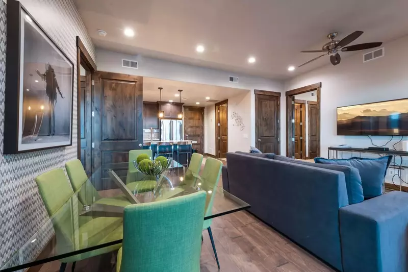 The dining room has a custom glass dining table and comfortable upholstered chairs, beautiful lighting, and outstanding views!