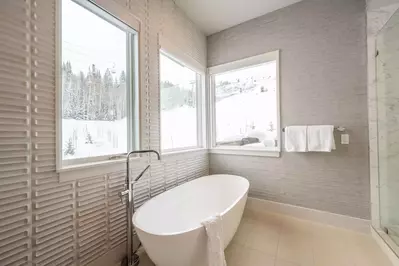 Private spa in the primary suite features sweeping mountain views, a freestanding large soaking tub, walk in glass