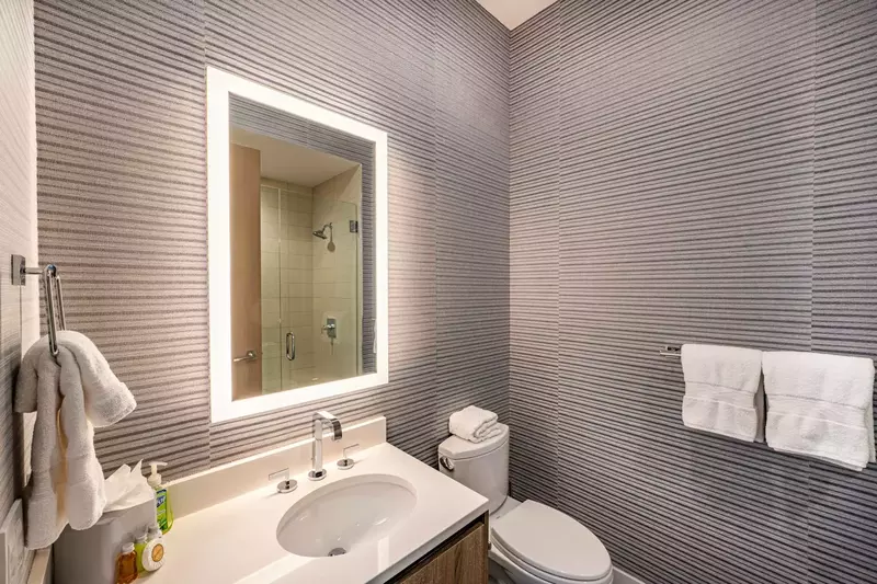 This is the En Suite Bathroom for the third guest Suite, featuring an LED Mirror, Quartz Vanity and Walk in Glass Shower.