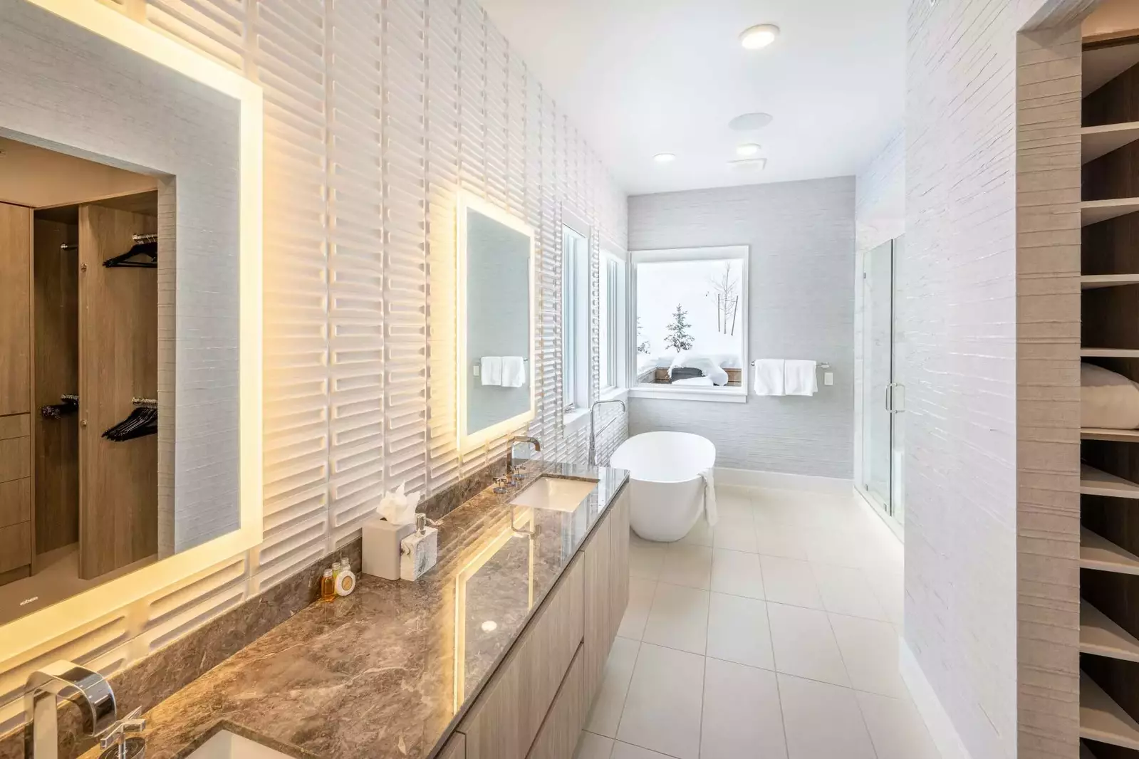 Adjacent to the freestanding soaking tub is a walk in glass shower and a large double marble vanity, each with it's own LED backlight mirrors. Each ba