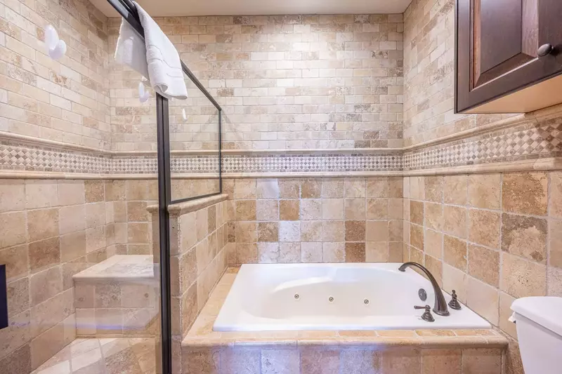 The primary suite has a jetted tub and a walk in glass enclosed rainfall shower!