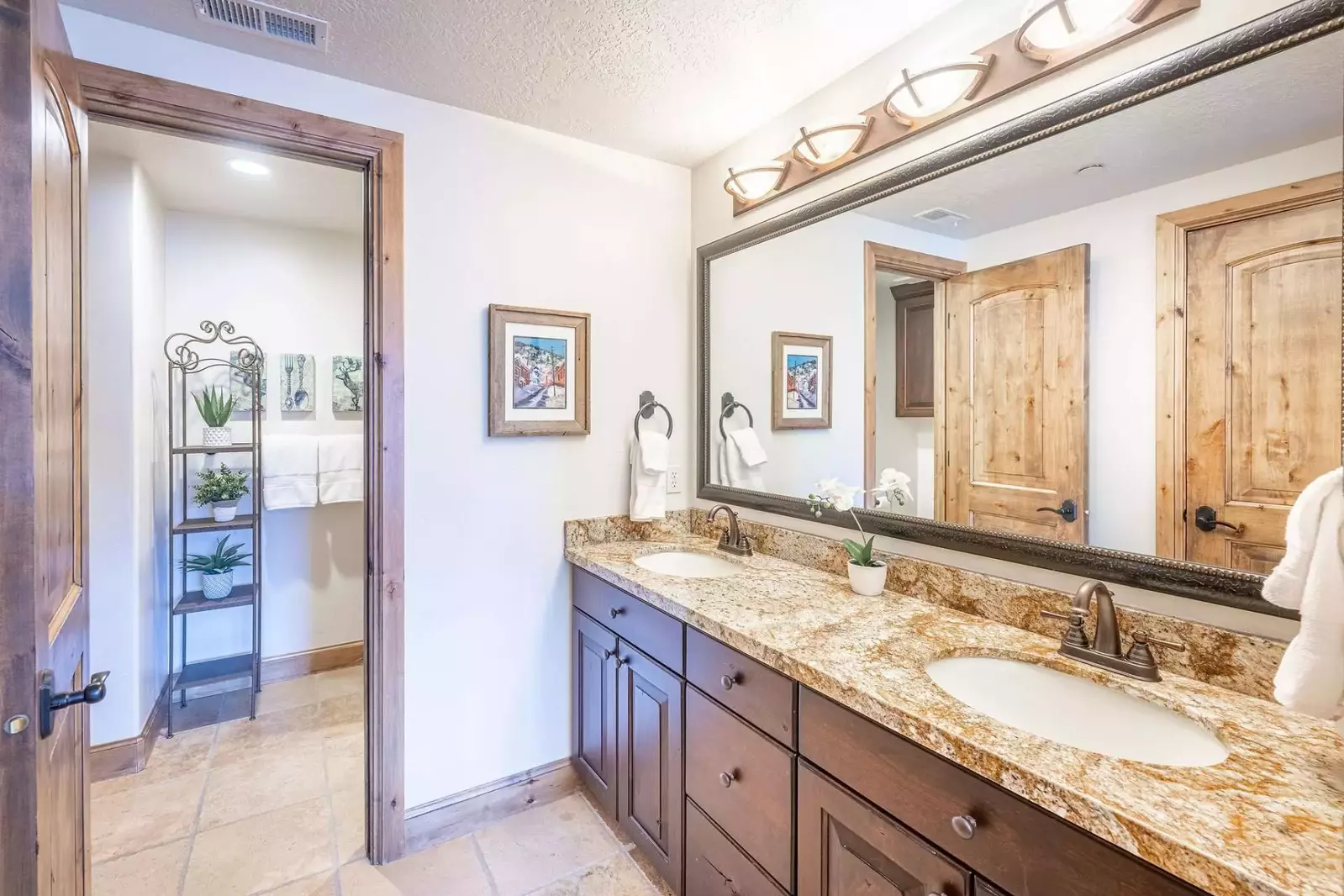 This is the guest en suite bathroom featuring dual vanities, walk in closet and private shower/bath and toilet areas.