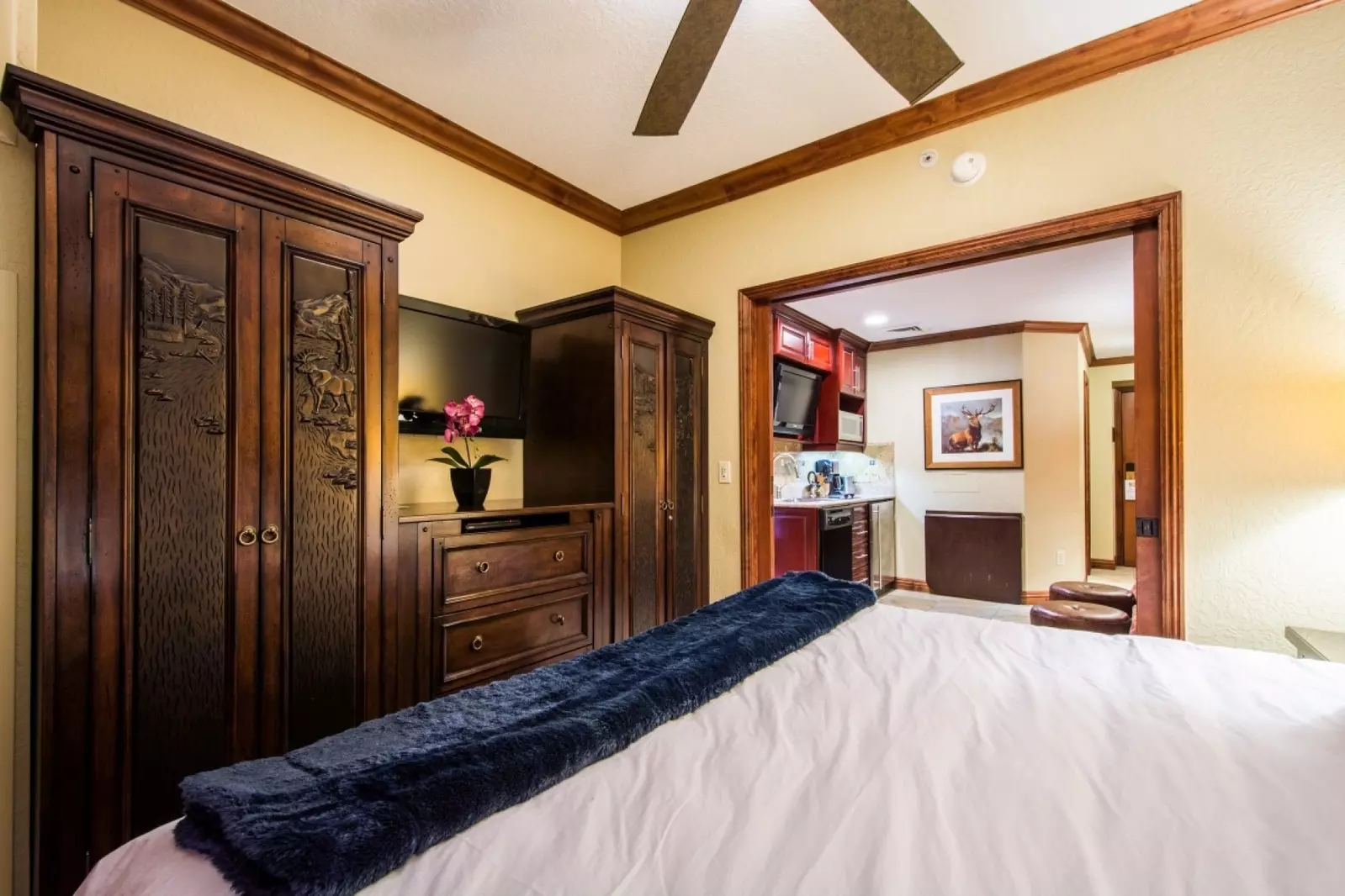The second Primary Suite separated by pocket doors from the living area, features a king size bed with luxury linens & bedding, large armoire and dres