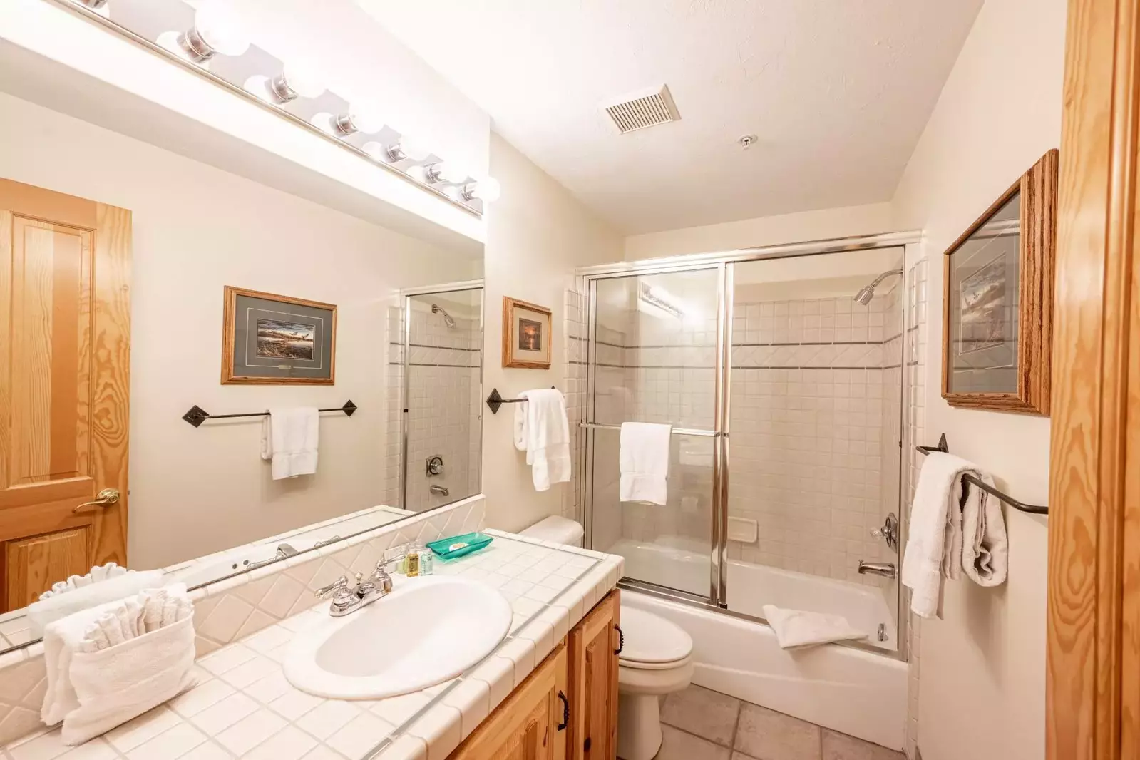 En Suite Bathroom with tiled vanity, tub, glass shower
