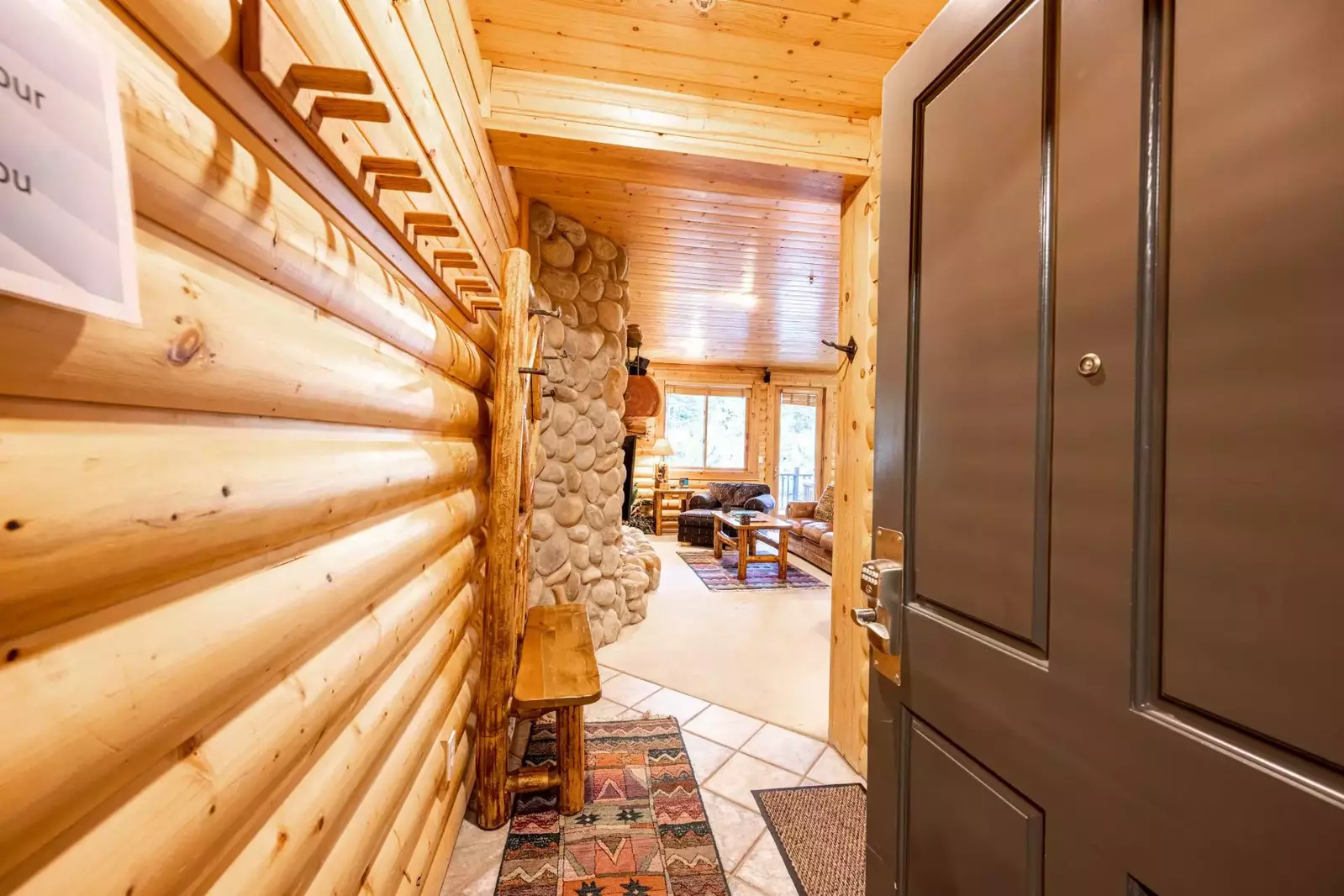 Classic mountain décor elements of interior log walls, hardwood ceilings and floors