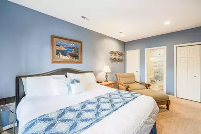 Primary (1) suite features a king size bed, flatscreen TV, large dresser, reading nook, with access to private balcony.