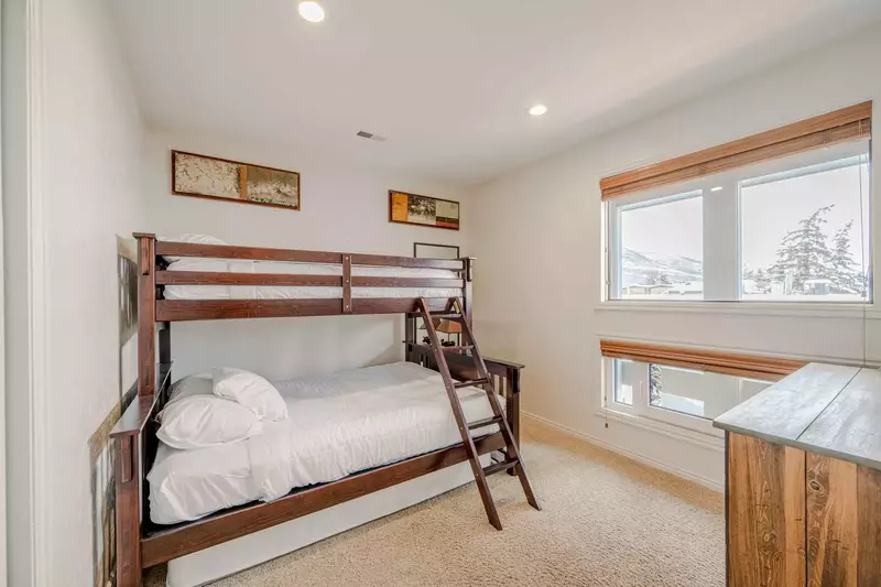 Comfortable guest room, featuring a bunk bed that sleeps three with a twin on top and queen on bottom. Extra trundle bed underneath.
