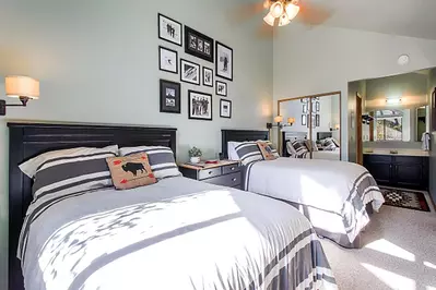 The first guest loft suite is bright & open with vaulted ceilings, two comfortable beds, remodeled bathroom with modern upgrades & decor throughout