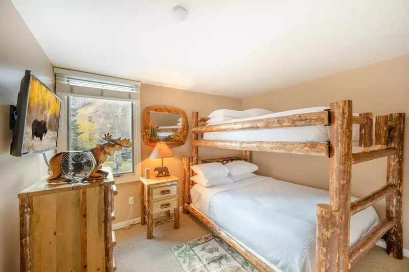 The first bedroom is equipped with a beautiful log bunk bed frame with a queen size bed on lower bunk and double bed on upper. Guests can also view th