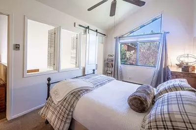 Spacious and Bright Guest Suite has a Queen Bed, Mountain Views, Large hardwood dresser for storage, ceiling fan, Barn Door, Loft shutters for privacy