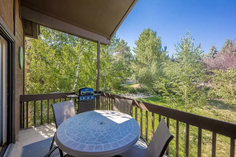 The private balcony is in a quiet setting and has dining furniture and an outdoor gas grill.