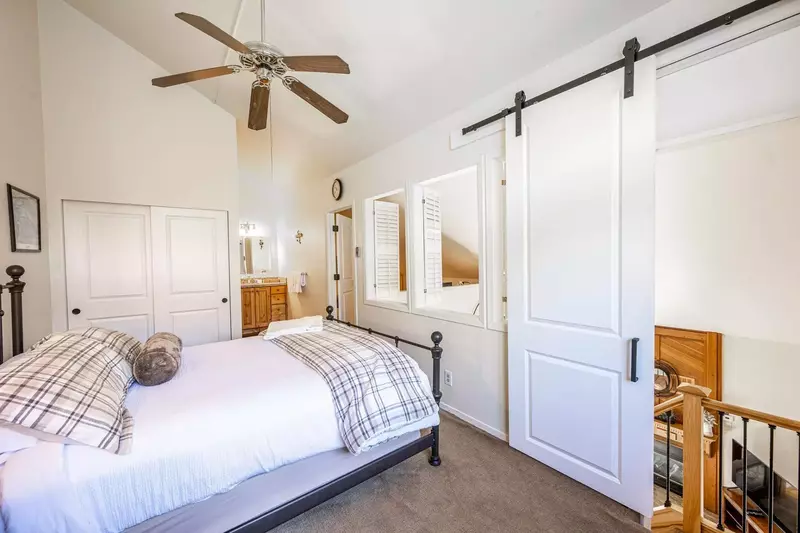 Spacious and Bright Guest Suite has a Queen Bed, Mountain Views, Large hardwood dresser for storage, ceiling fan, Barn Door, Loft shutters for privacy