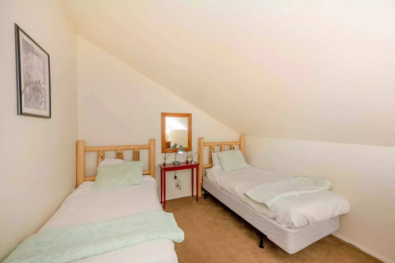 The loft bedroom features two twin beds, large dresser and nightstand. Both bedrooms on the upper floor share the bathroom