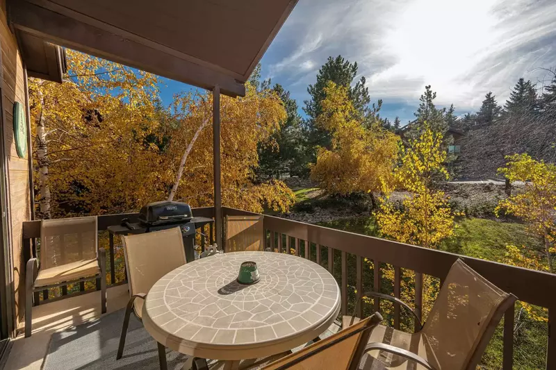 The private balcony is in a quiet setting and has dining furniture and an outdoor gas grill.