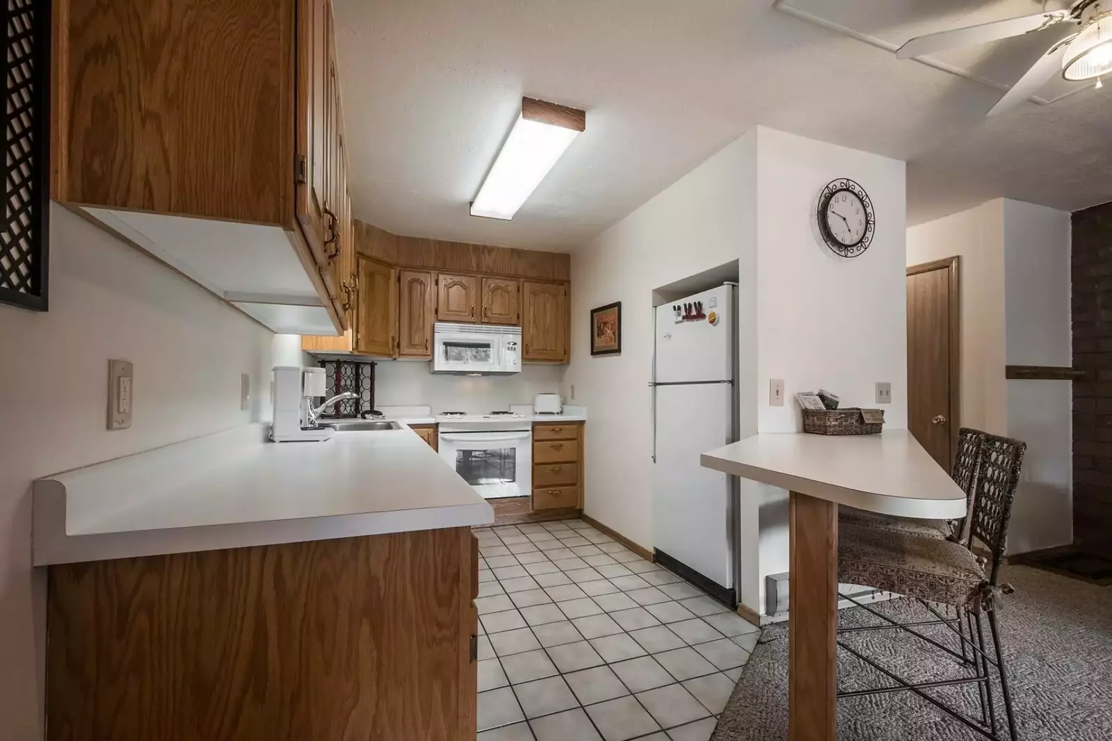The kitchen is equipped with appliances including a fridge, stove/oven, microwave and dishwasher and stocked with cookware, flatware and dishes.